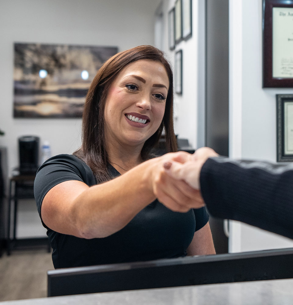front desk welcoming dental patient